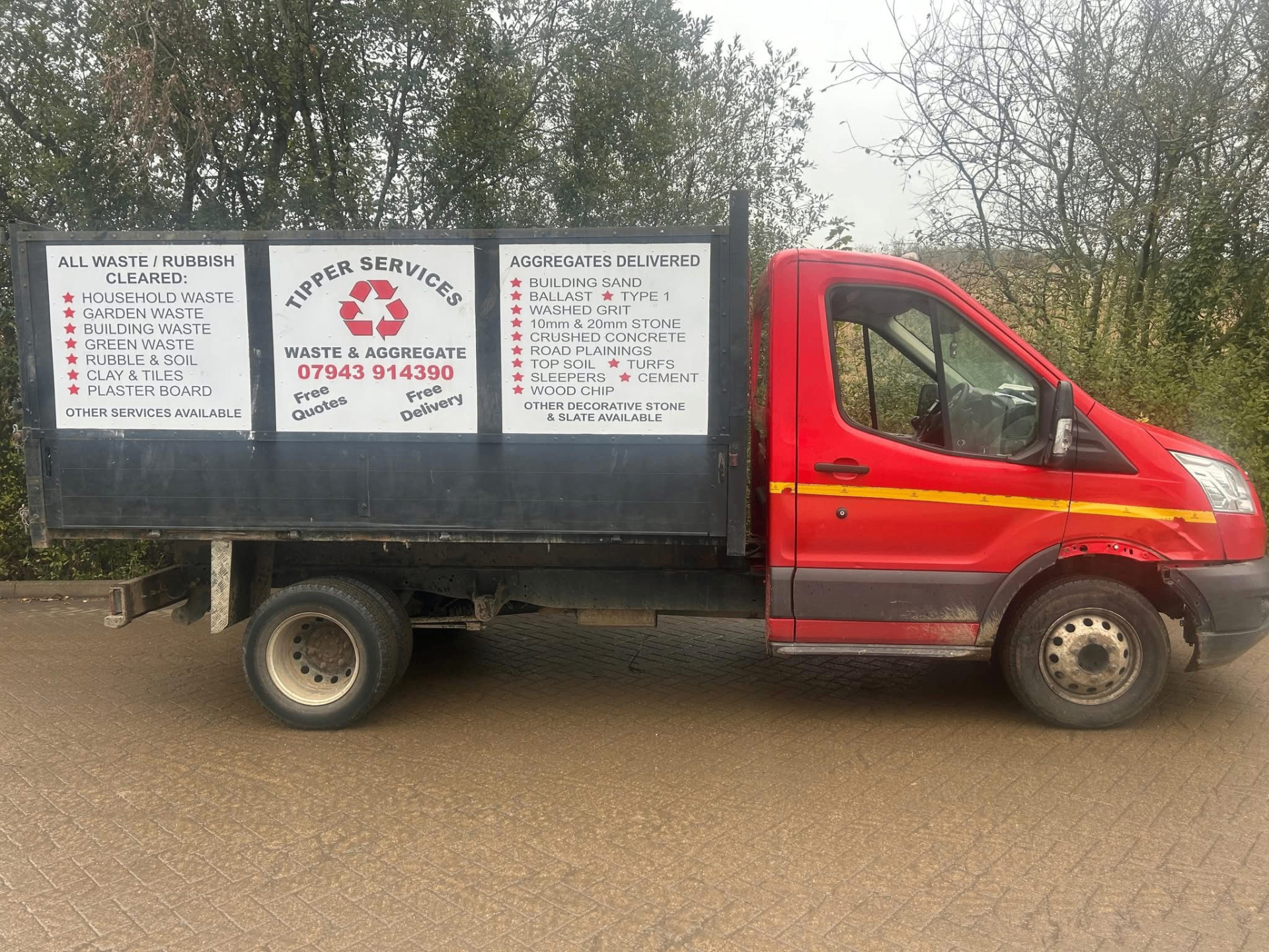 Red Tipper Services truck loaded with garden waste, parked on an Isle of Wight street